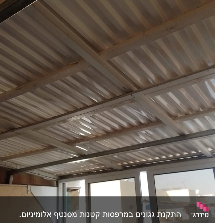 גג מתכת עם קורות עץ תומכות